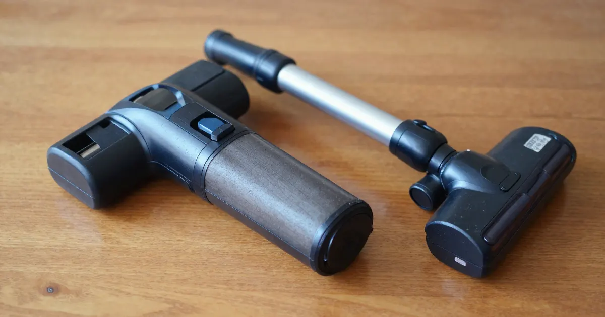 Illustration of a generic handheld vacuum body and extension wand on a wooden table