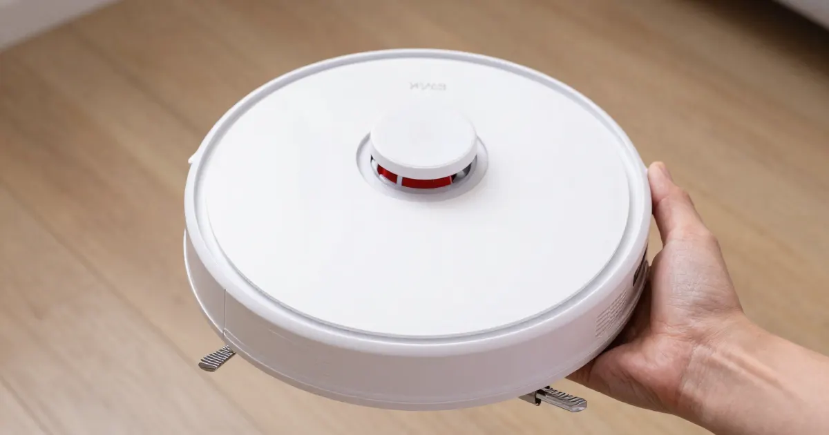 Illustration of a hand holding a generic white robot vacuum