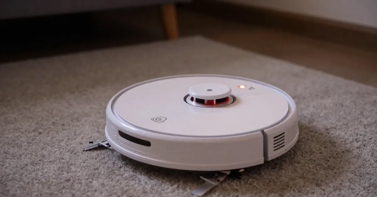 Illustration of a generic robot vacuum stopped on a rug with a small light glowing on top