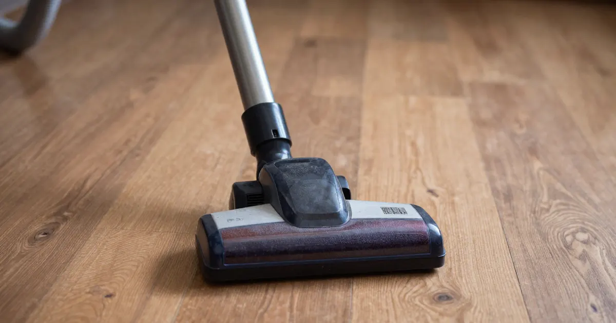 Illustration of a generic vacuum wand and floor head on a wooden floor