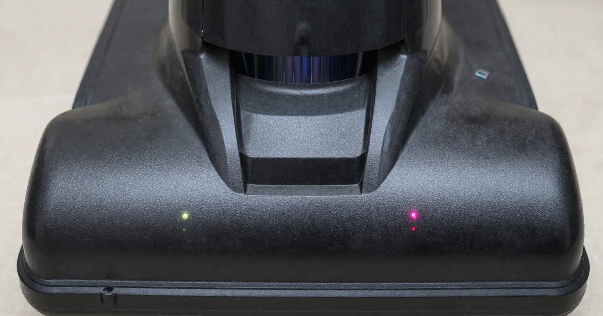 Illustration of a close-up of the base of a generic cordless floor washer with two small indicator lights