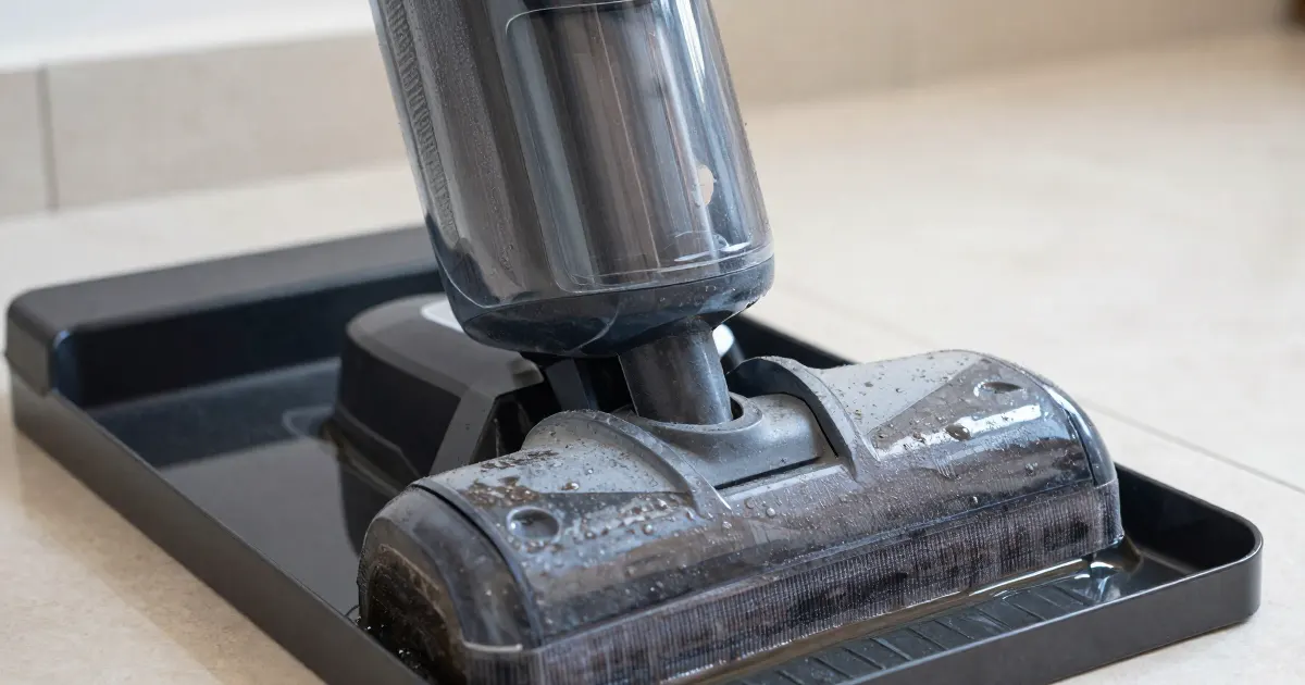 Illustration of a generic cordless floor washer standing in its cleaning tray on a tiled floor